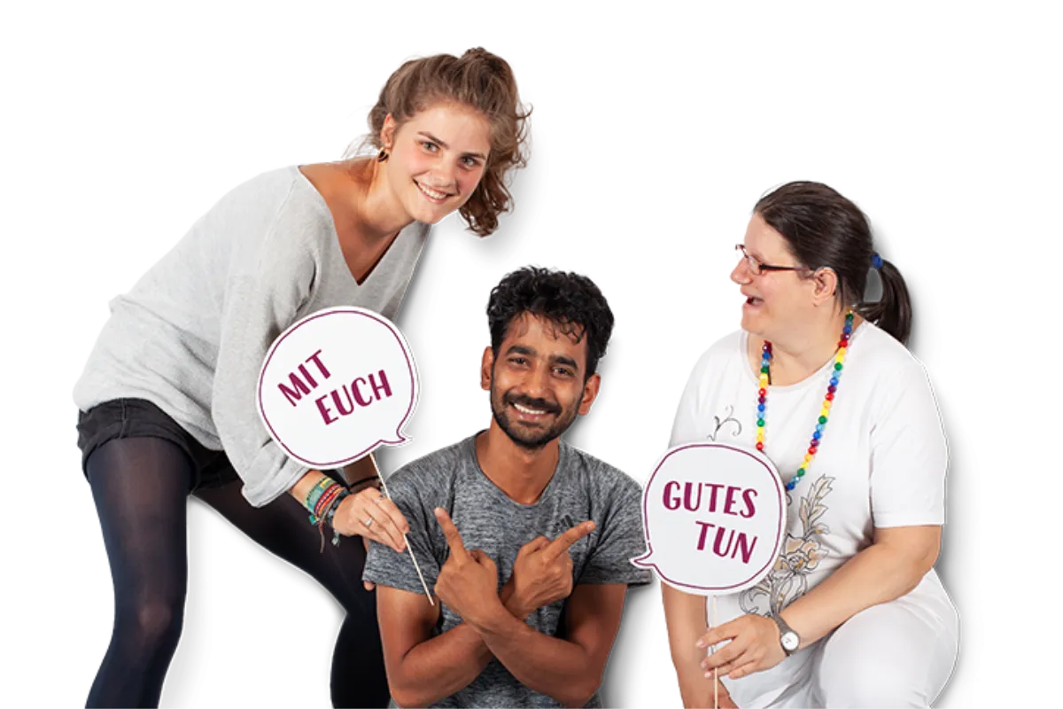 Zwei Frauen und ein junger Mann schauen fr&ouml;hlich und halten Pappschilder in den H&auml;nden