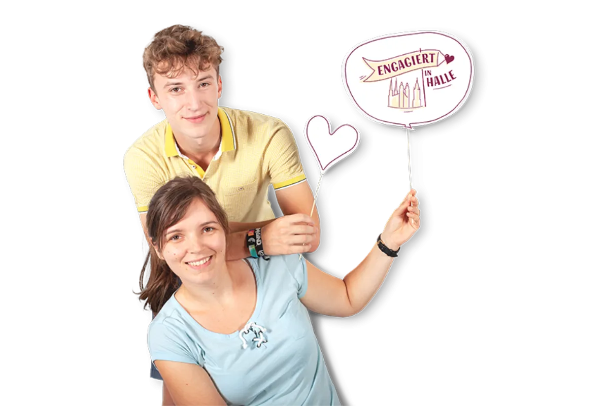 Ein junger Mann lehnt an einer jungen Frau und beide halten Pappschildchen hoch
