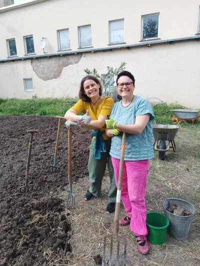 Zwei fr&ouml;hliche Frauen beim Freiwilligentag im Garten des Kinderbauernhofes Kanena
