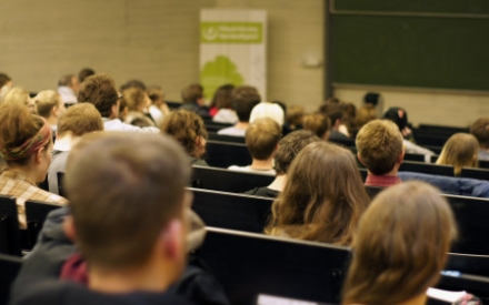 Es ist eine Situation in einem H&ouml;rsaal an der Universit&auml;t in Halle zu sehen. Es sind viele K&ouml;pfe von Menschen von hinten zu sehen, die in Reihen sitzen und nach vorne Richtung Tafel schauen.