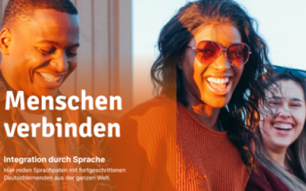 Junge Menschen stehen im Licht der Abendsonne und lachen in die Kamera.