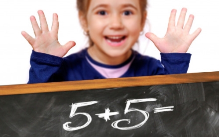 Ein M&auml;dchen zeigt das Ergebnis der Rechenaufgabe 5 + 5 mit ihren 10 Fingern.