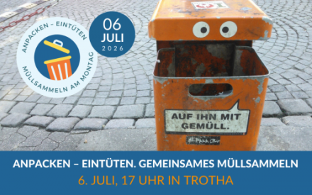 Ein gro&szlig;er orangefarbener M&uuml;lleimer aus Metall steht an einer gepflasterten Stra&szlig;e. Auf der oberen Frontseite des M&uuml;lleimers sind zwei gro&szlig;e Augen aufgeklebt. Auf dem unteren Teil ist ein Aufkleber mit der Aufschrift "Auf ihn mit Gem&uuml;ll"