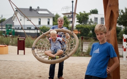 Ein Familienpate mit zwei Kindern auf dem Spielplatz