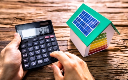 Taschenrechner und Modellhaus mit Solarzellen