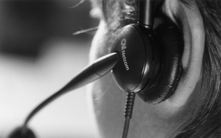 halb von hinten ist ein Kopf zusehen mit einem Headset