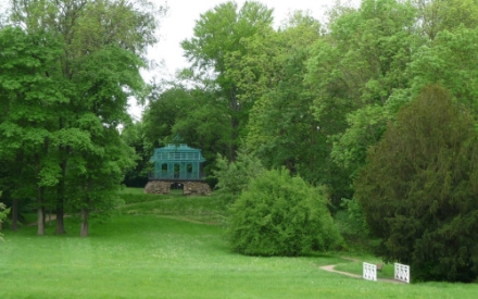 Eine gro&szlig;e Wiese mit B&auml;umen im Dieskauer Park, das Teehaus im Hintergrund.