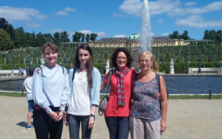 4 Frauen stehen vor dem Brunnen auf dem Gel&auml;nde des Schlosses Sanssoucci und l&auml;cheln in die Kamera.