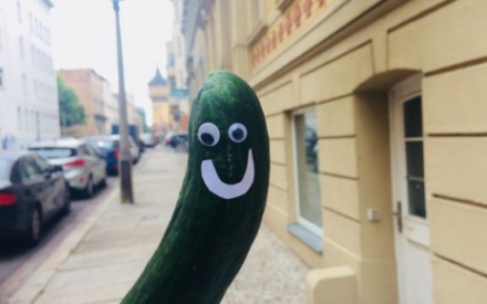 Eine krumme Gurke mit aufgeklebten Wackelaugen und Mund vor dem Ladengesch&auml;ft vom Crummen Eck.