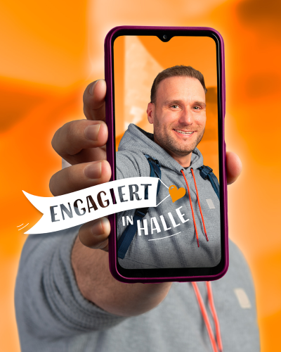 Ein Mann hält sein Handy hoch, auf dem sein Gesicht zu sehen ist