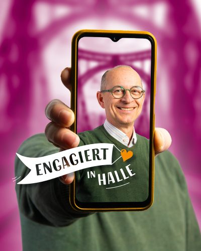 Ein Mann hält ein Handy vor sich hoch