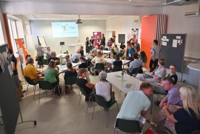 Eine Gruppe Menschen mit einer Präsentation der Klimaplattform www.klima-engagiert-in-halle.de im Hindergrund