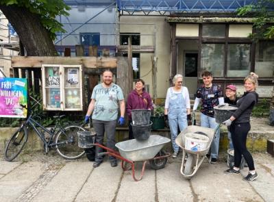 Aufräumen im Quartierstreff Eine Gruppe Menschen mit Handwerkszeug vor einem Haus