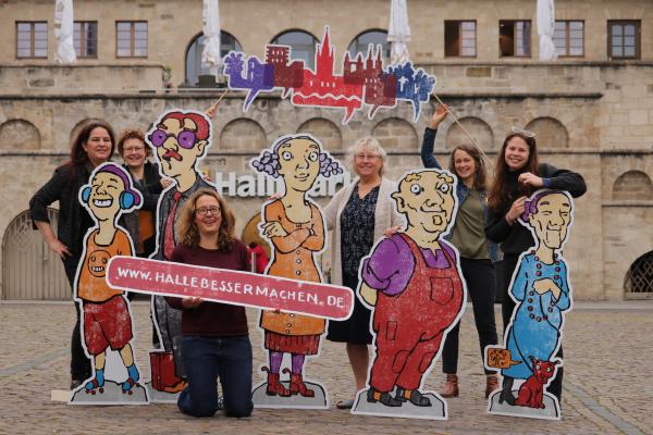 6 Frauen stehen mit Pappfiguren auf dem halleschen Hallmarkt